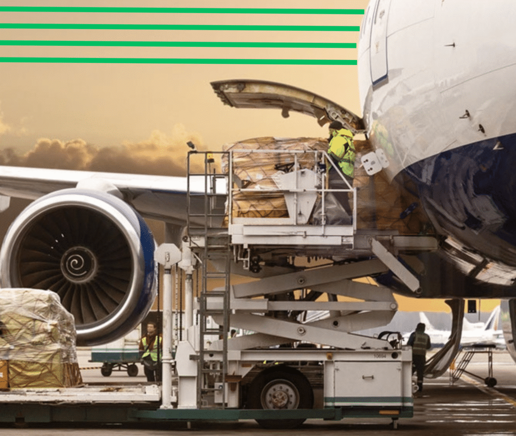 A high-loader vehicle lifting wrapped cargo pallets into the open belly compartment of a commercial freight airplane on an airport tarmac.