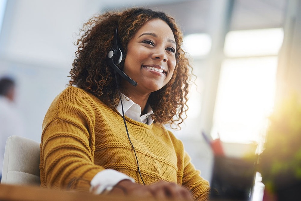 Express Shipping: Why Speed Matters More Than Ever for Businesses A smiling customer support representative wearing a headset, providing friendly and helpful assistance to a client over the phone.